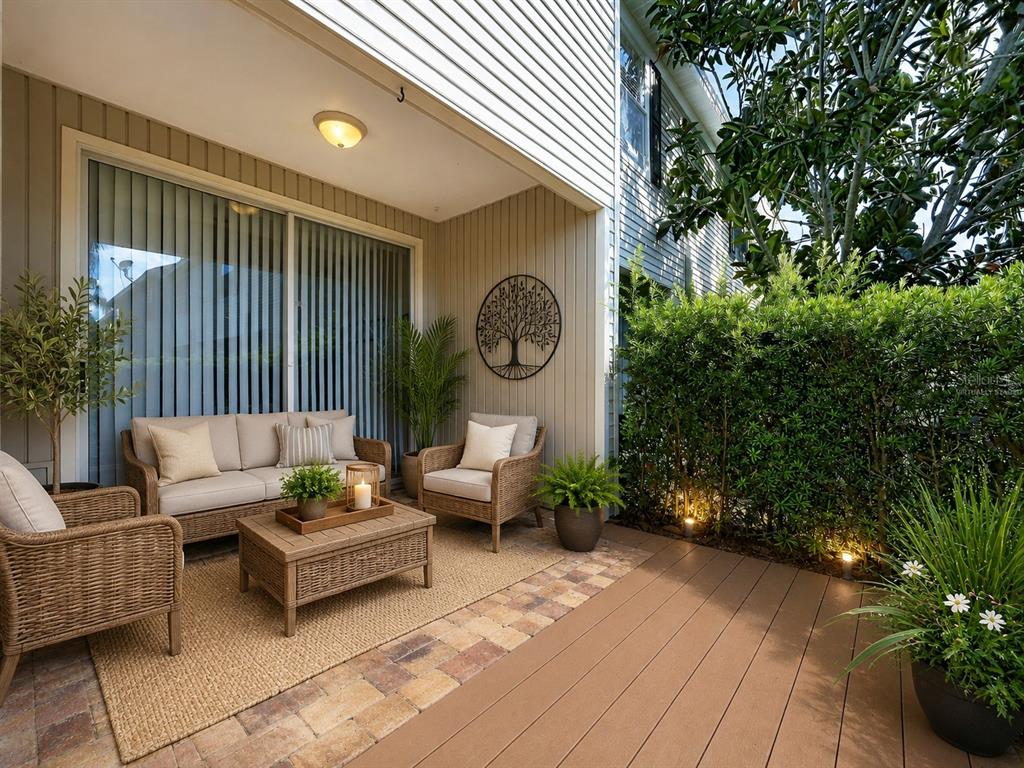A patio features wicker furniture, a coffee table, and a tree wall art piece — 12207 COUNTRY WHITE CIRCLE, TAMPA, FL