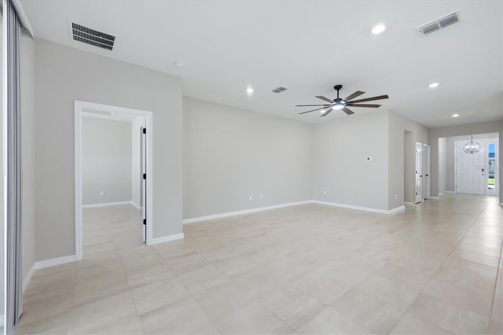 A spacious, light-filled living area features neutral tile flooring, recessed lighting, and a ceiling fan — 12413 DORA TRAIL, PARRISH, FL