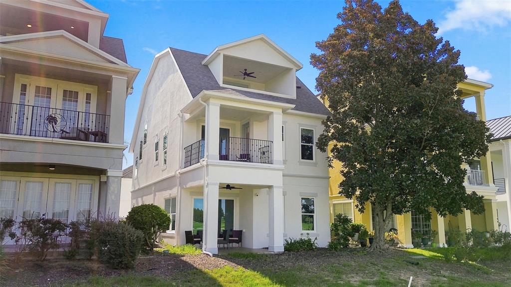 A two-story house with a white stucco exterior and two gray arched garage doors — 1530 COROLLA COURT, REUNION, FL