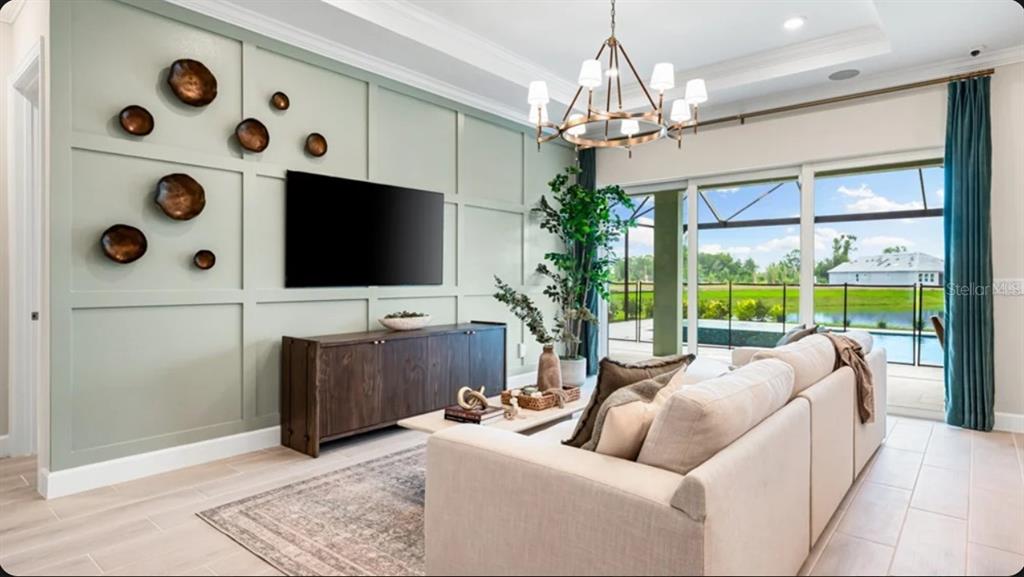 A kitchen features a large island with bar seating, wooden cabinetry, and glass pendant lights — 7636 MOONBEAM AVENUE, SARASOTA, FL