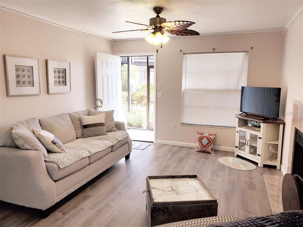 A living room features a gray sofa, a ceiling fan, and a television on a stand — 3773 59TH AVENUE W, BRADENTON, FL