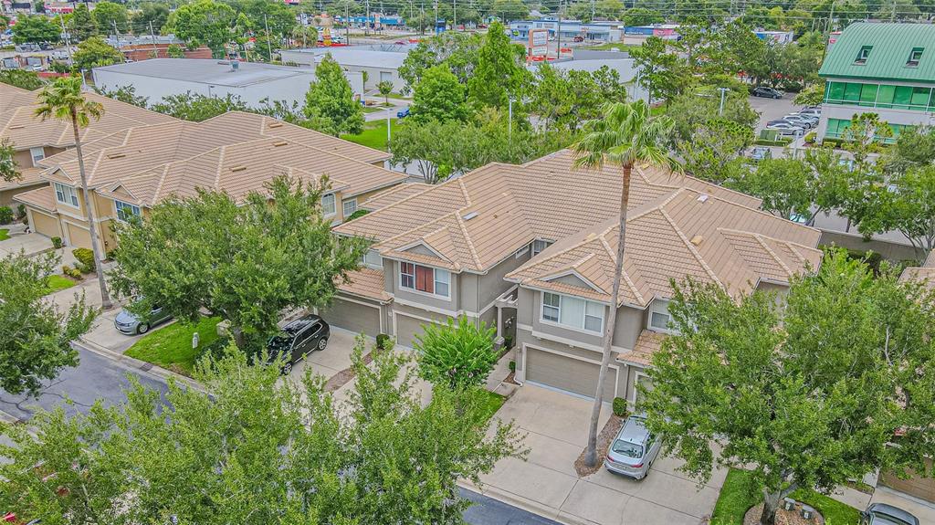 An aerial view of a multi-unit residential building with tan tile roofs and driveways — 3331 COVERED BRIDGE DRIVE E, DUNEDIN, FL