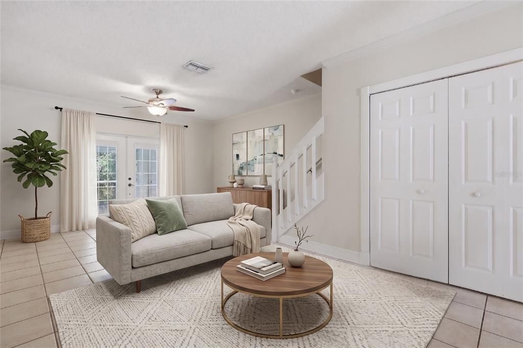 A living room features a light gray sofa, a round wooden coffee table, and stairs — 5416 CARROLLWOOD KEY DRIVE UNIT 8, TAMPA, FL