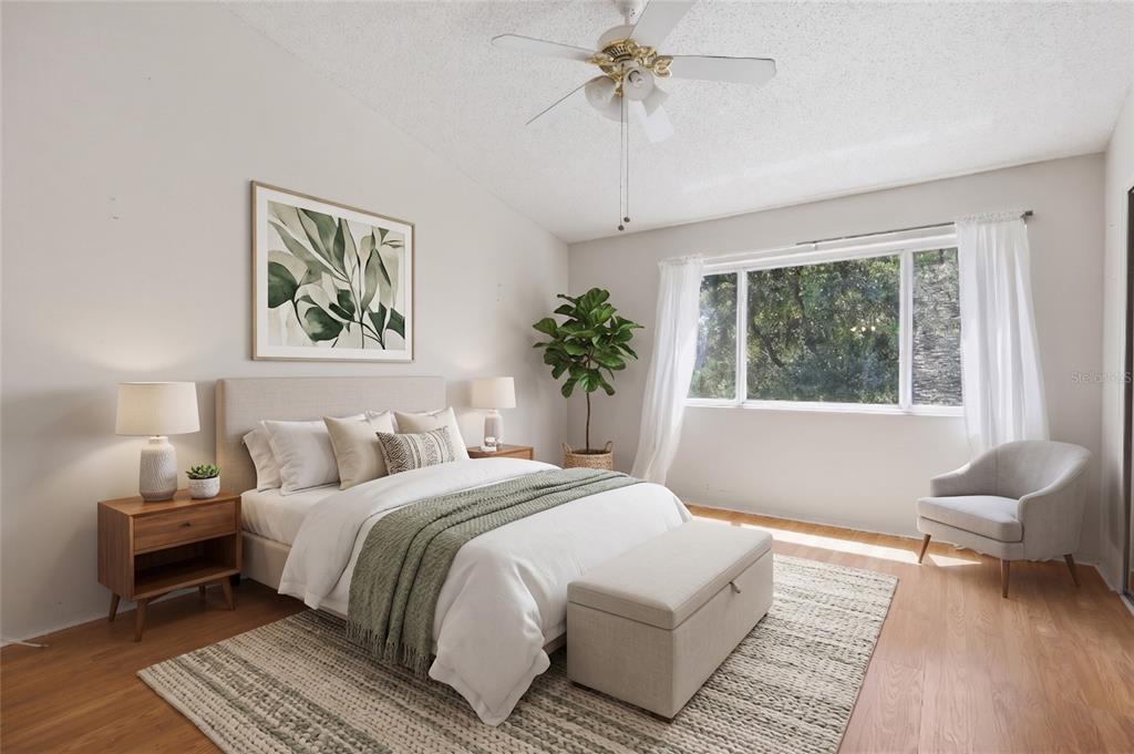 A bedroom features a bed with a green throw, a ceiling fan, and a window — 5416 CARROLLWOOD KEY DRIVE UNIT 8, TAMPA, FL