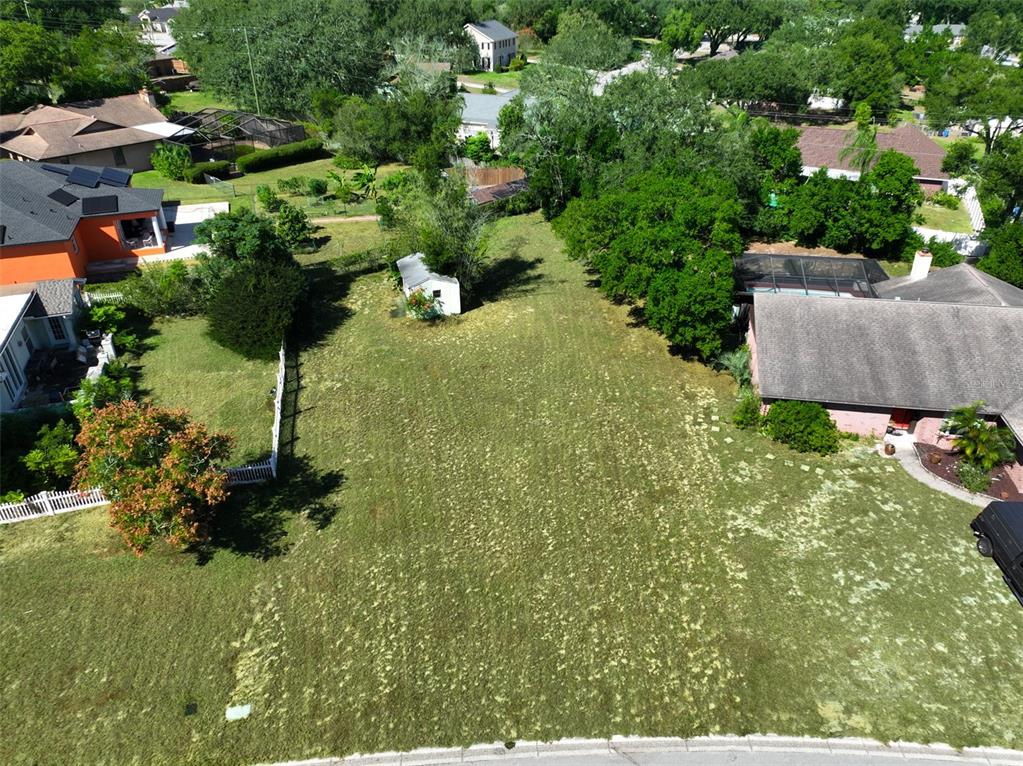 An aerial view shows a vacant grassy lot situated between two residential houses — 1114 CLASSIC DRIVE, VALRICO, FL