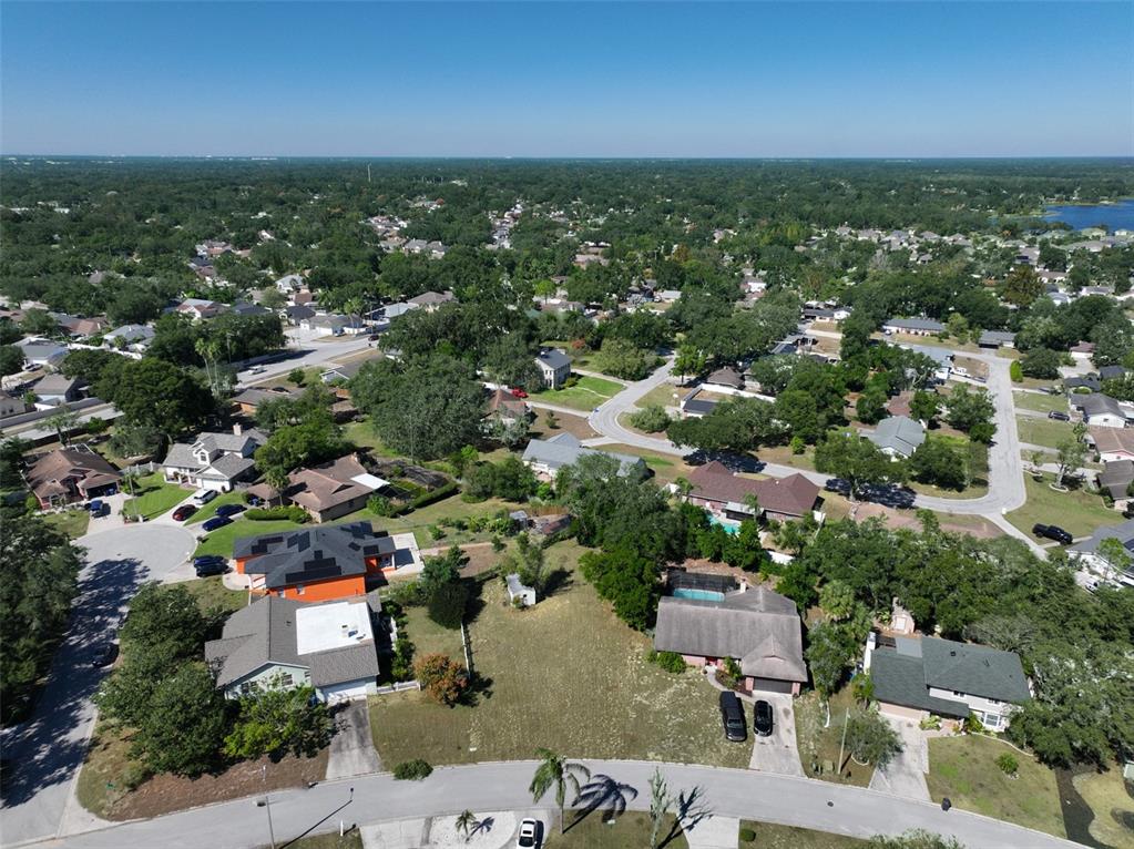 An aerial view shows a suburban neighborhood with single-family homes, paved streets, and mature trees — 1114 CLASSIC DRIVE, VALRICO, FL