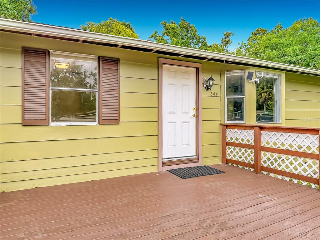 A one-story house with olive green siding, a front deck, and a bay window — 544 MERCURY AVENUE, ORLANDO, FL
