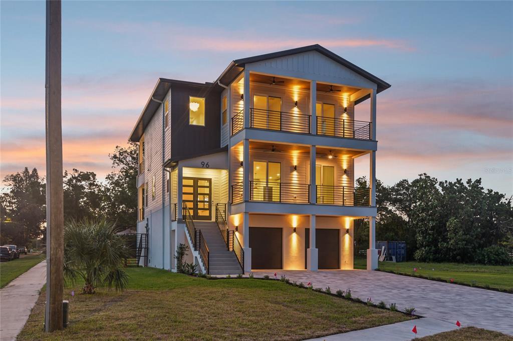 A three-story elevated house with two levels of balconies and a ground-level garage — 96 SHORE DRIVE, TARPON SPRINGS, FL