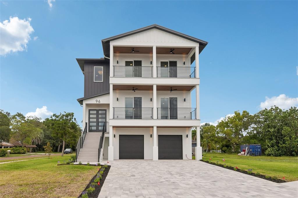 A balcony with a black metal railing overlooks a coastal park and the ocean — 96 SHORE DRIVE, TARPON SPRINGS, FL