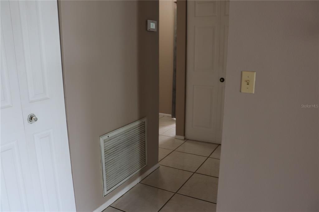 A hallway features tiled flooring, a white louvered vent, and two white interior doors — 11012 BRIGHTSIDE DRIVE, TAMPA, FL