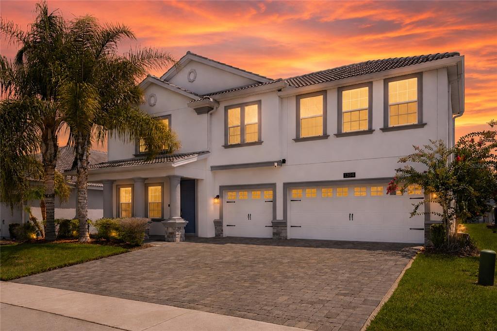 A two-story white house with a paver driveway and a three-car garage — 1394 OLYMPIC CLUB BOULEVARD, CHAMPIONS GATE, FL