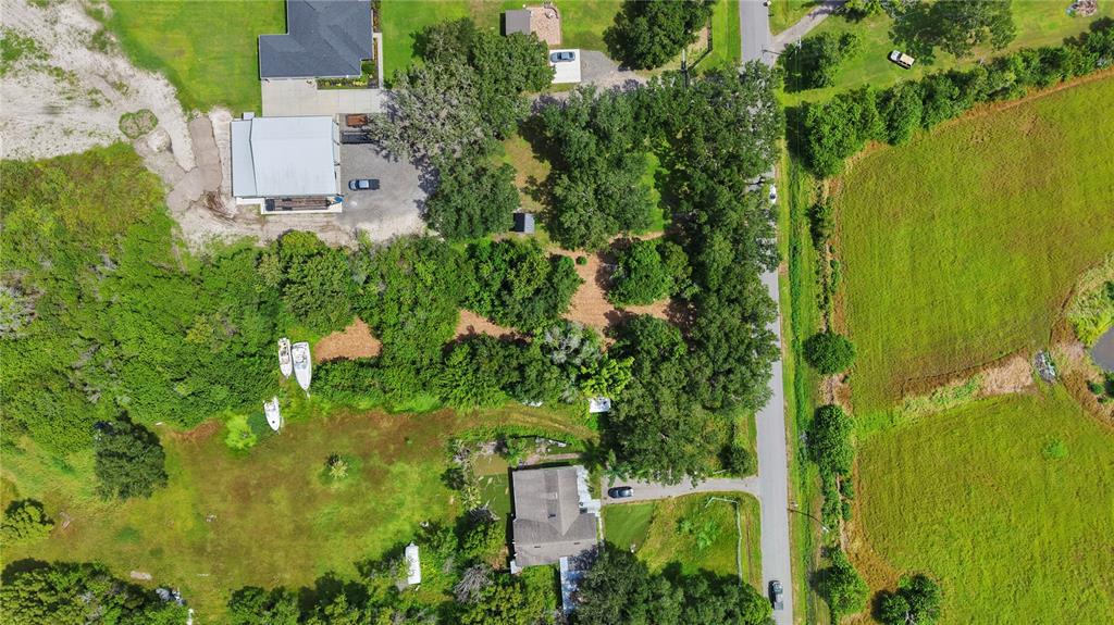 An aerial view shows two houses, a large metal workshop, and wooded land along a road — 3120 CHEROKEE ROAD, ST CLOUD, FL