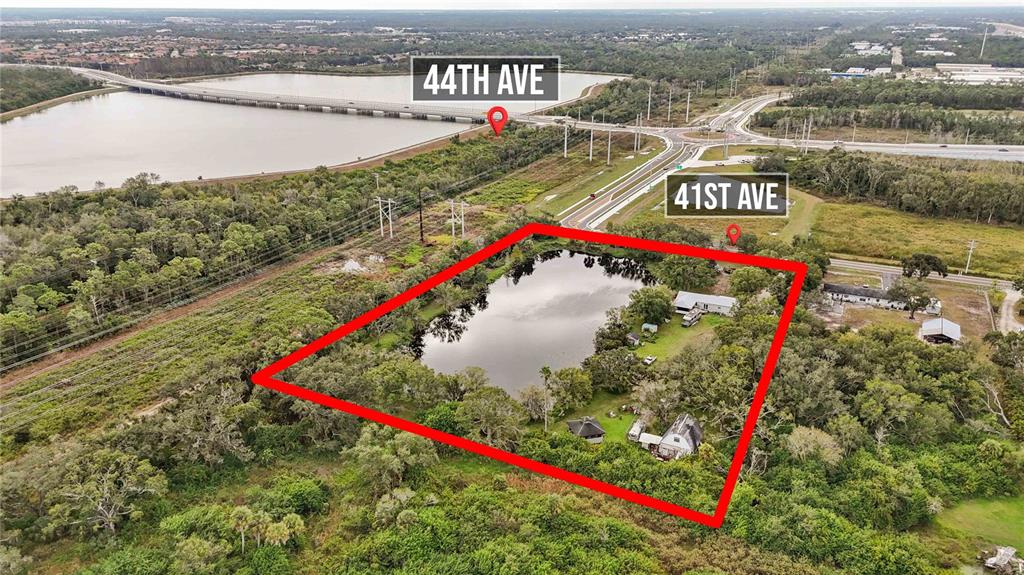 An aerial view shows a rectangular property containing a pond, trees, and several small buildings — 8011 41ST AVENUE E, BRADENTON, FL