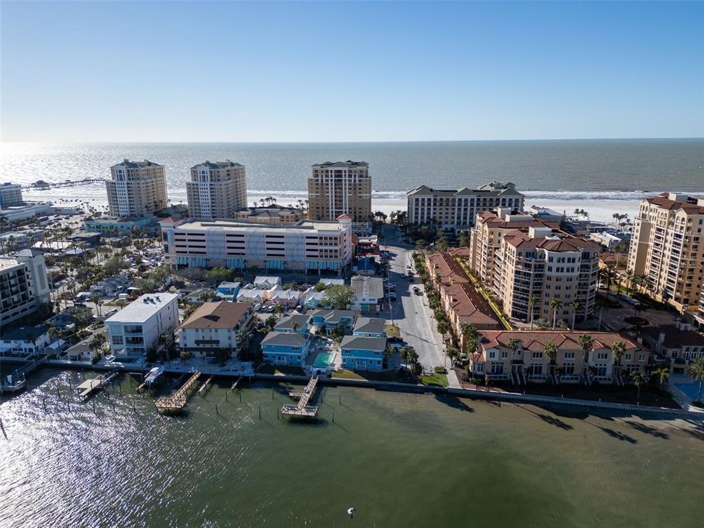 A blue two-story building sits beside a rectangular swimming pool overlooking a bay — 483 E SHORE DRIVE UNIT D4, CLEARWATER BEACH, FL
