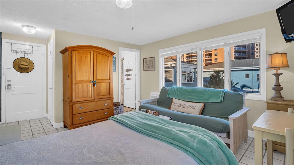 A studio apartment features a Murphy bed, a small kitchen, and a wooden armoire — 483 E SHORE DRIVE UNIT D4, CLEARWATER BEACH, FL