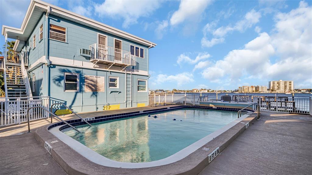 A studio apartment features a sofa, a dining table, a Murphy bed, and a kitchenette — 483 E SHORE DRIVE UNIT D4, CLEARWATER BEACH, FL