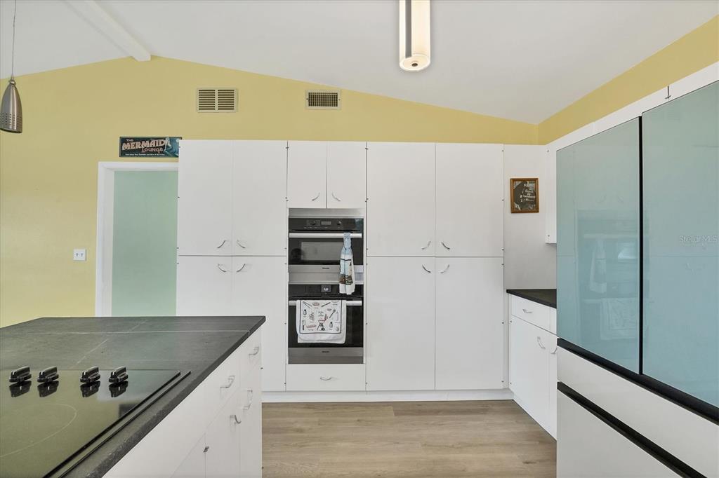 A kitchen features white cabinetry, a built-in double oven, and a dark countertop island — 45 CAPE HAZE DRIVE, PLACIDA, FL