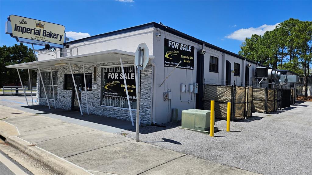 A single-story commercial building with a stone facade and a for sale sign — 830 E MAIN STREET, LAKELAND, FL