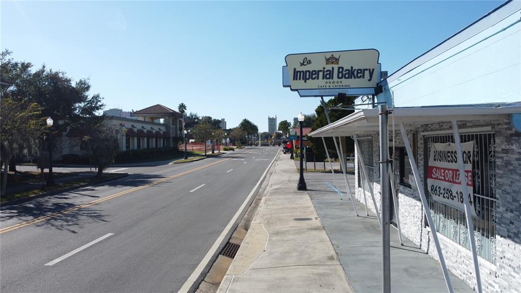 A street view shows a bakery building with a for sale or lease sign — 830 E MAIN STREET, LAKELAND, FL