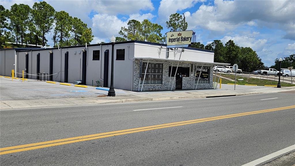 A single-story commercial building with a "For Sale" sign and a bakery sign — 830 E MAIN STREET, LAKELAND, FL