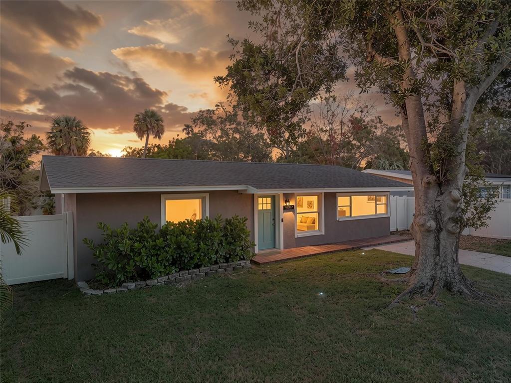 A single-story house with a gray exterior, teal front door, and a large tree outside — 4227 HARRISBURG STREET NE, ST PETERSBURG, FL