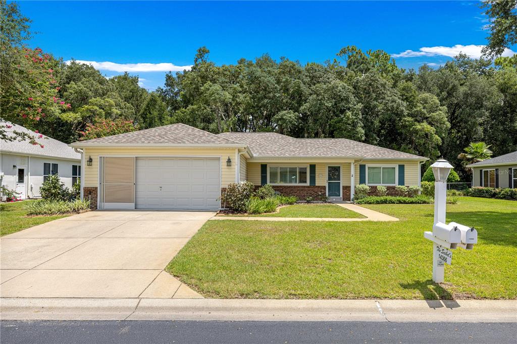 A single-story house with a yellow exterior, a two-car garage, and a front lawn — 14366 SW 115TH CIRCLE, DUNNELLON, FL