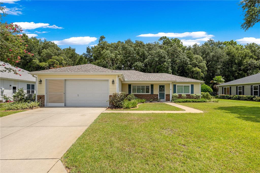 A single-story house with a light yellow exterior, a garage, and a front lawn — 14366 SW 115TH CIRCLE, DUNNELLON, FL