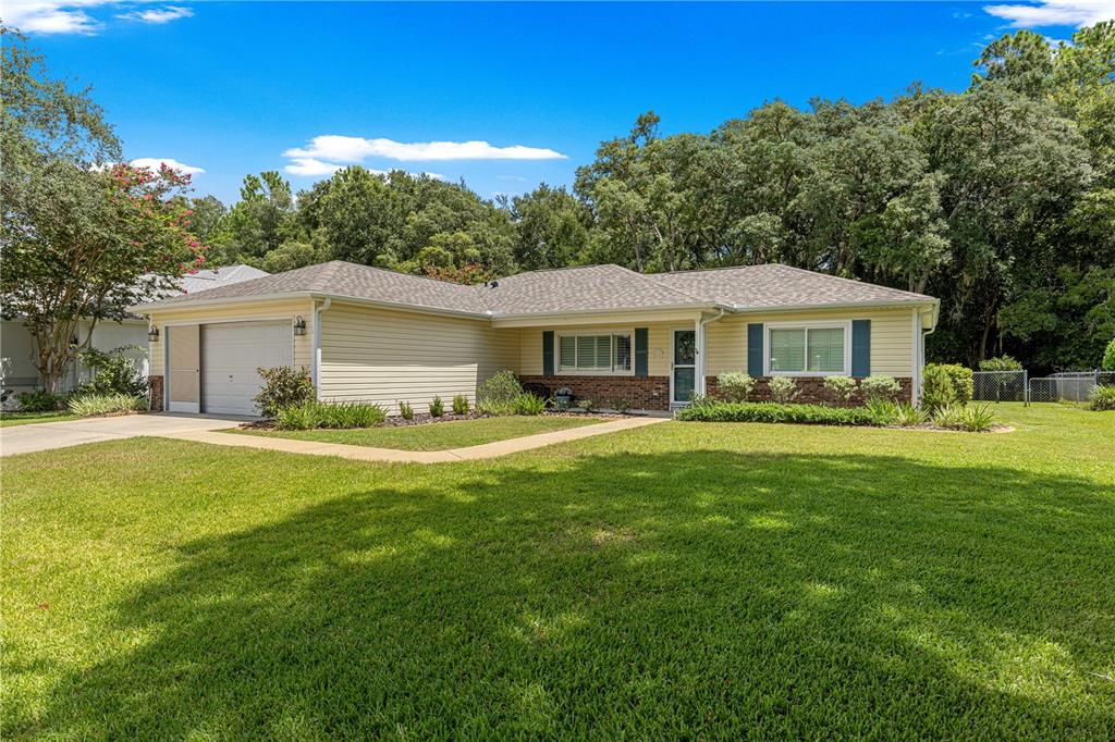 A single-story house with beige siding, a garage, and a large front lawn — 14366 SW 115TH CIRCLE, DUNNELLON, FL