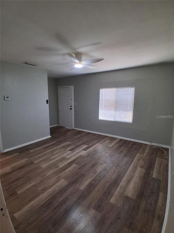 An empty room features gray walls, wood-look flooring, a ceiling fan, and a single window — 506 N MACDILL AVENUE, TAMPA, FL