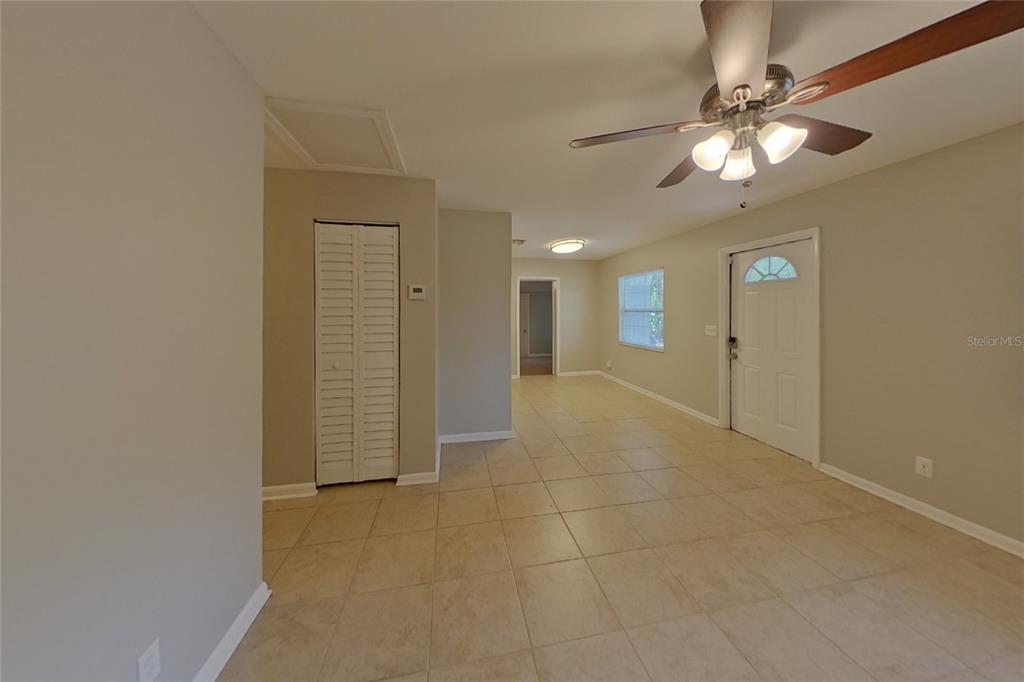 A tiled living area features a ceiling fan, a white front door, and a closet — 4313 W BAY AVENUE, TAMPA, FL