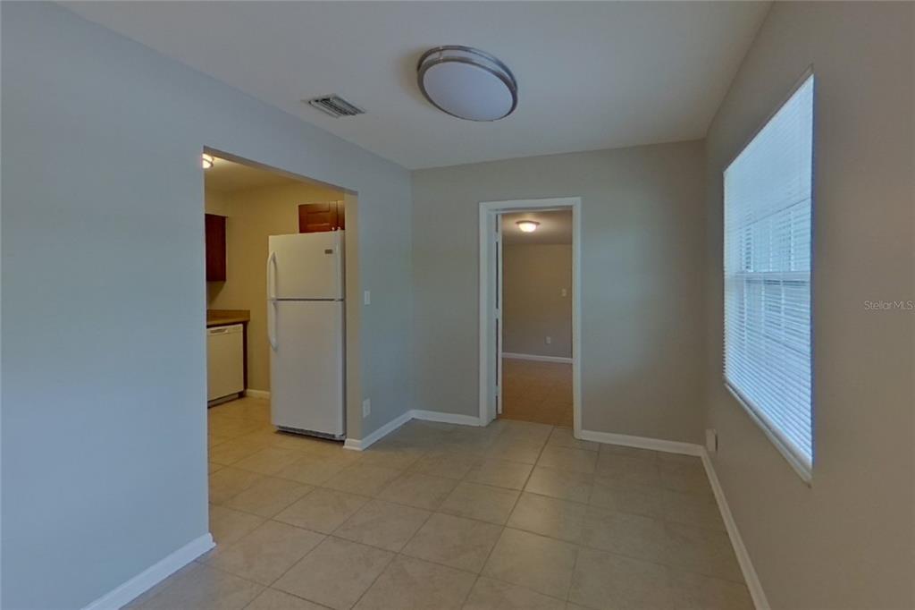 A dining area with tile flooring, a ceiling light, and a doorway leading to a kitchen — 4313 W BAY AVENUE, TAMPA, FL