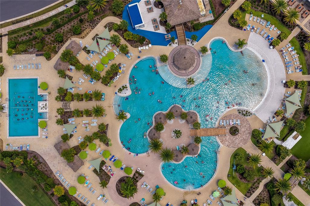 An aerial view shows a large swimming pool complex with multiple sections, lounge chairs, and landscaping — 237 SAND BAR LANE, DAYTONA BEACH, FL