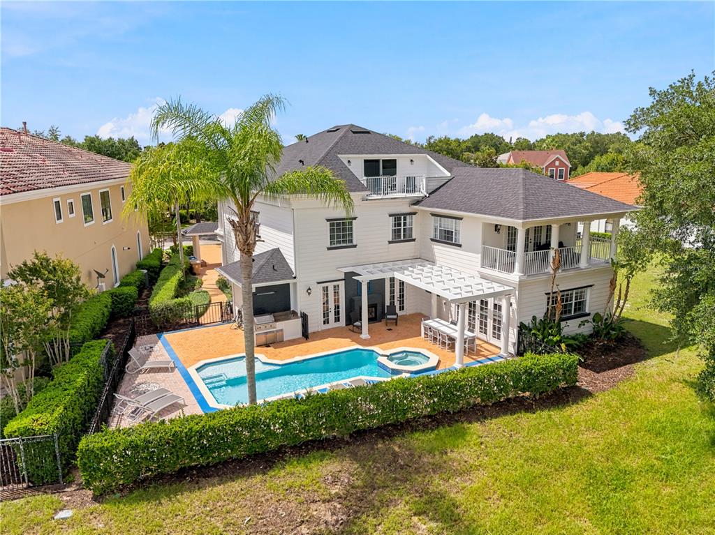 A two-story white house features a brick driveway, a covered entryway, and a balcony — 7481 GATHERING LOOP, REUNION, FL