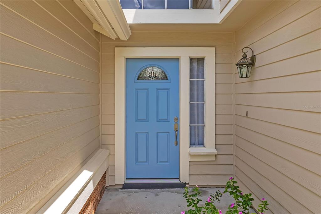 A two-story house with beige siding, a two-car garage, and a bright blue front door — 779 MEADOWSIDE COURT, ORLANDO, FL