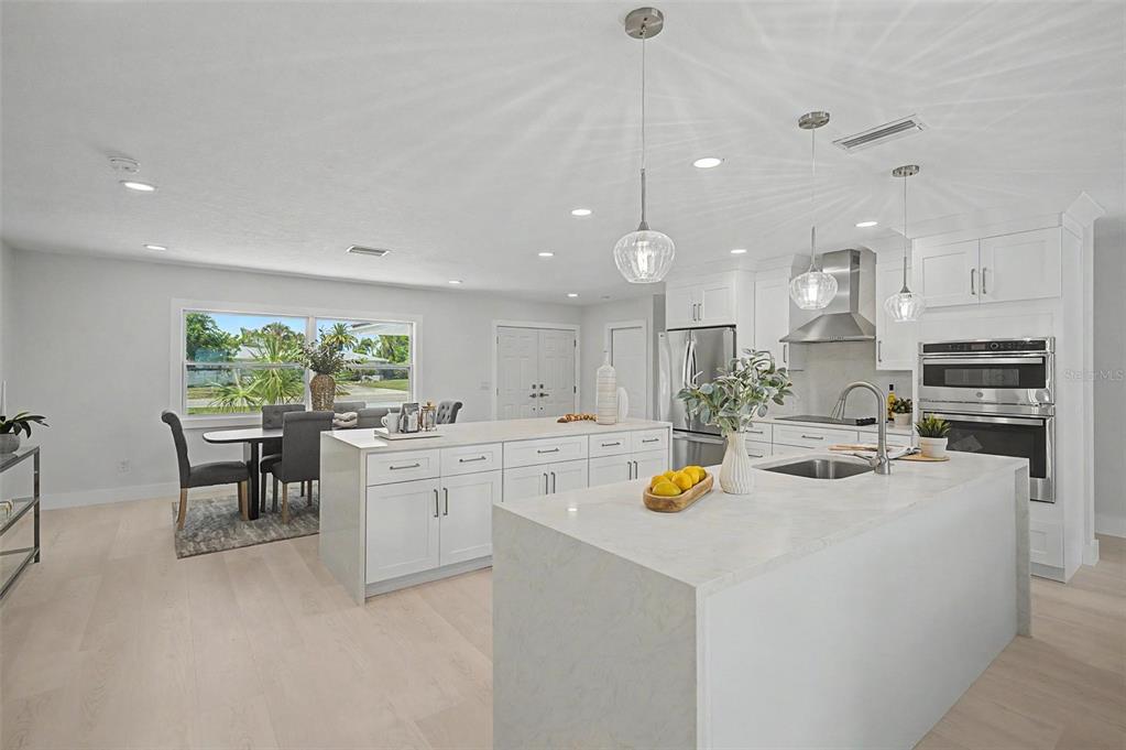This aerial view shows a residential neighborhood with canals, boat docks, and a private beach — 3340 FLORAMAR TERRACE, NEW PORT RICHEY, FL