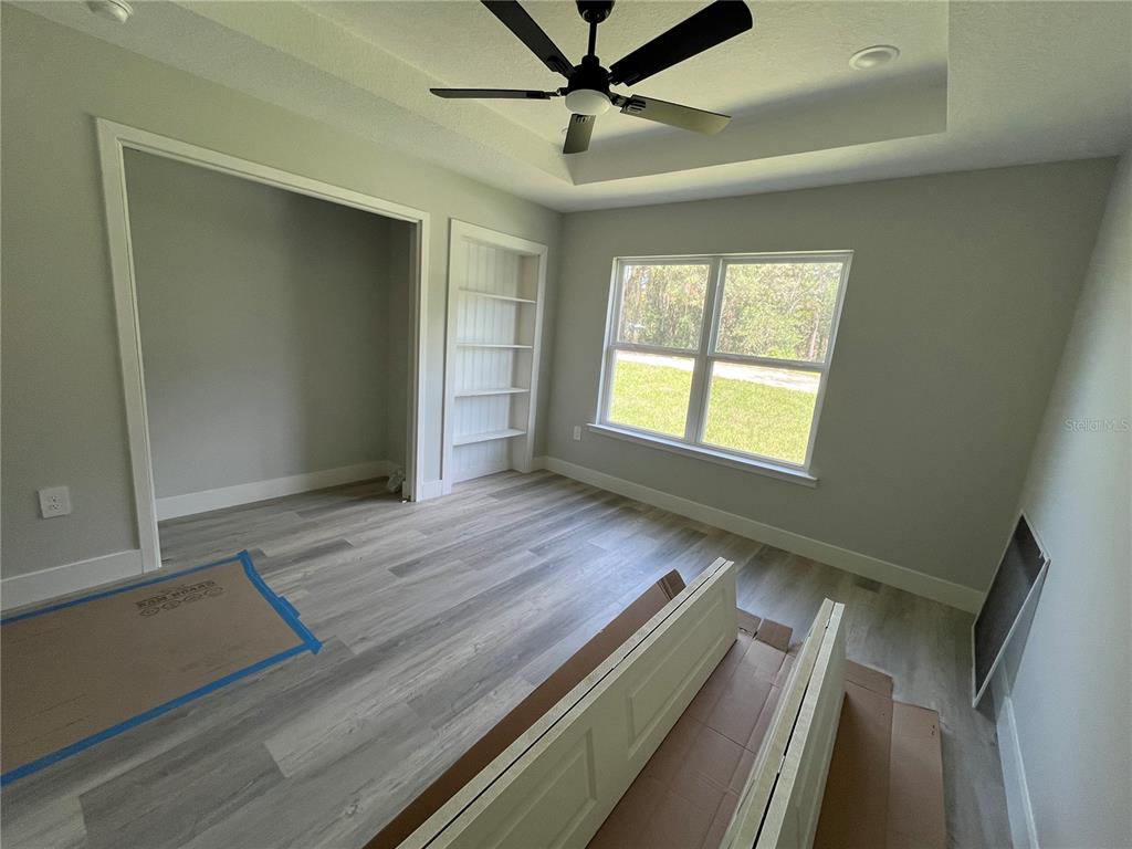 A modern bathroom features a marble-tiled walk-in shower, white vanity, and a vessel sink — 12728 SE 102ND TERRACE, BELLEVIEW, FL