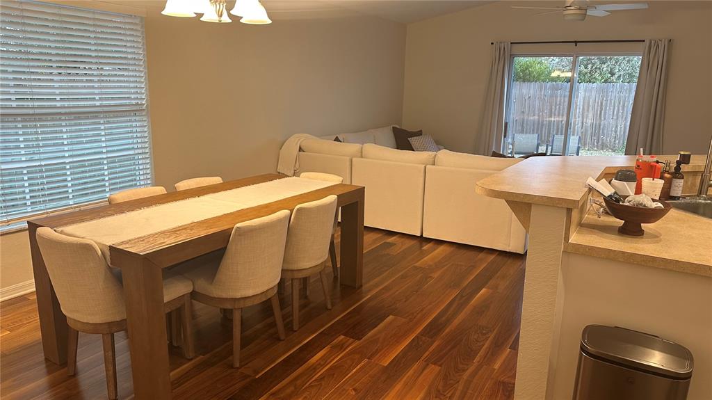 A dining area with a wooden table and chairs sits adjacent to a living room — 906 SE 5TH STREET, MULBERRY, FL
