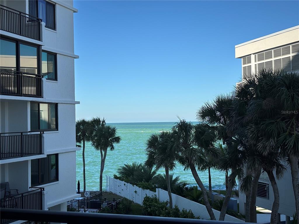 A view of the ocean from a balcony between two white multi-story buildings — 4822 OCEAN BOULEVARD UNIT 3D, SARASOTA, FL