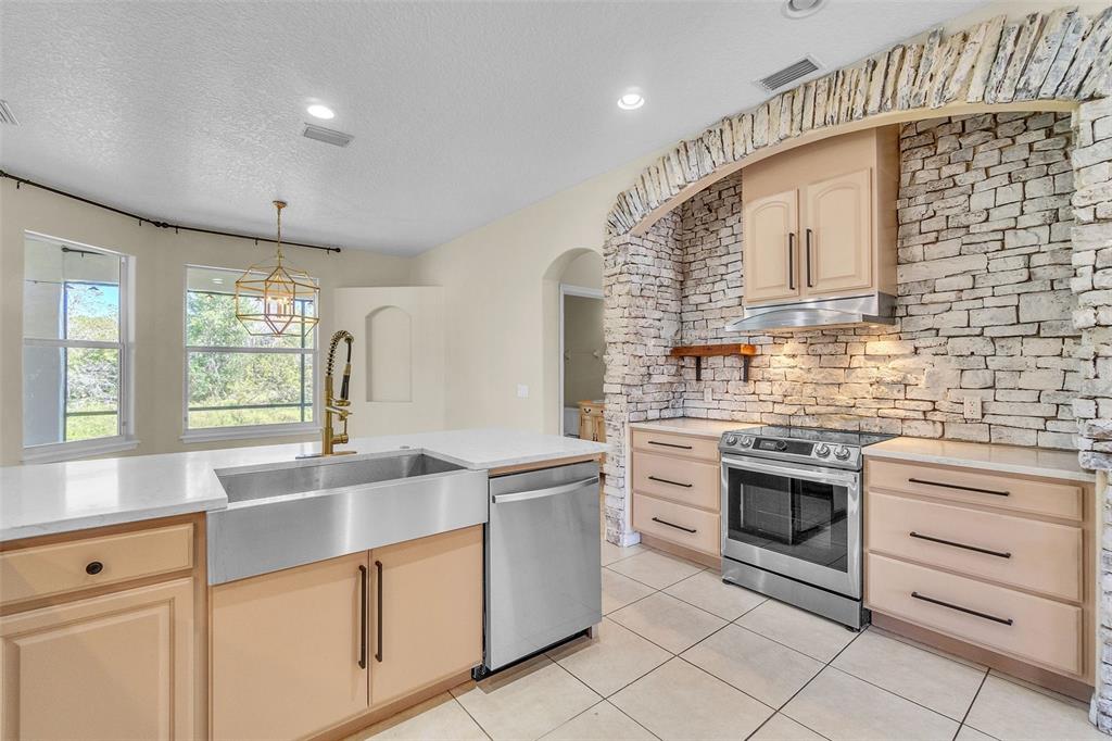 A room with hardwood floors, arched doorways, wooden double doors, and three large windows — 4617 PATRICIA ANN COURT, ORLANDO, FL