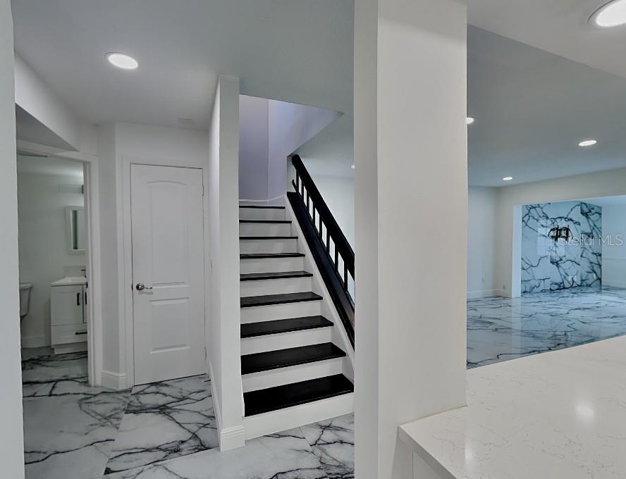 A room with white marble-patterned walls and flooring, a ceiling fan, and two skylights — 8212 CITRUS CHASE DRIVE, ORLANDO, FL