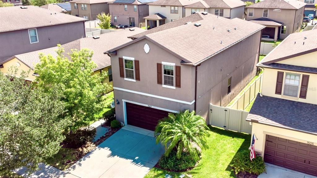 An aerial view shows a two-story suburban house with a brown roof and garage — 1507 GADSDEN POINT PLACE, RUSKIN, FL