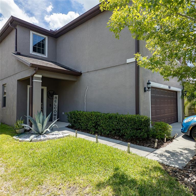 The exterior of a two-story house features a brown garage door and a covered entryway — 1507 GADSDEN POINT PLACE, RUSKIN, FL