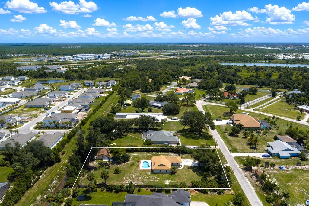 An aerial view shows a single-story house with a pool on a large, grassy lot — 2331 MISSION VALLEY BOULEVARD, NOKOMIS, FL