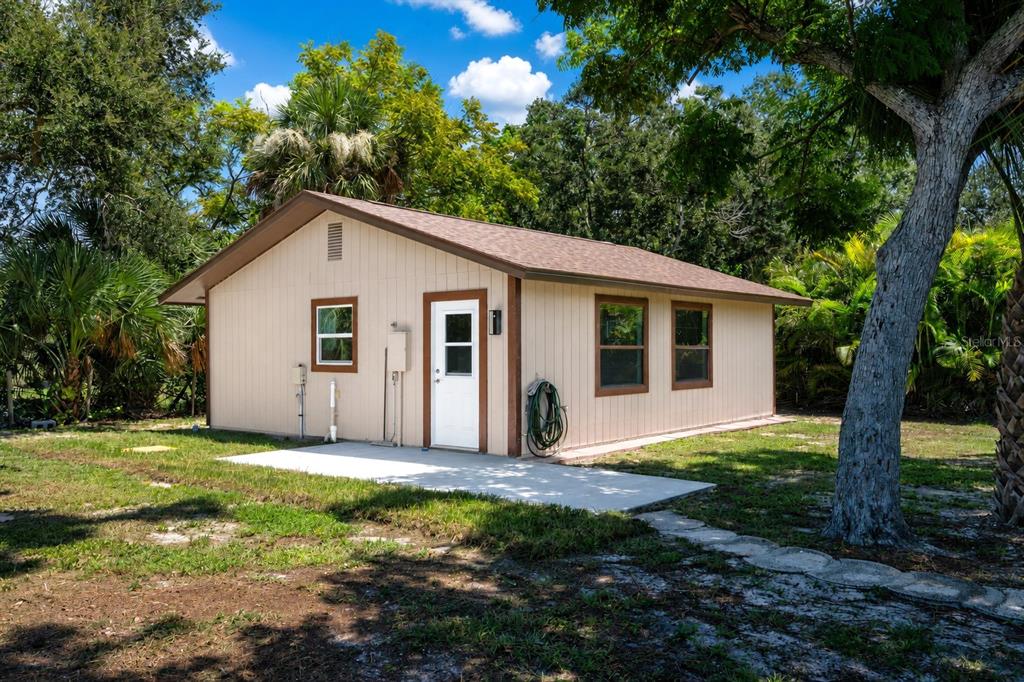 A tan, single-story detached building with a white door, brown trim, and a concrete patio — 2331 MISSION VALLEY BOULEVARD, NOKOMIS, FL