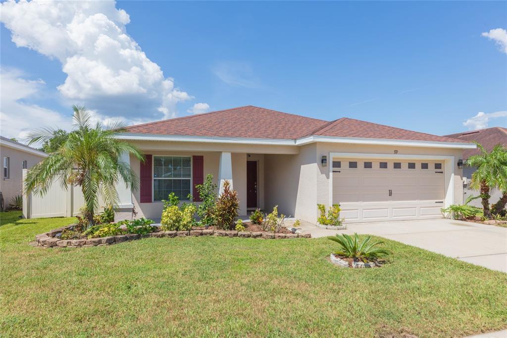 A single-story house with a beige stucco exterior, a two-car garage, and a front lawn — 719 VINEYARD RESERVE COURT, SEFFNER, FL