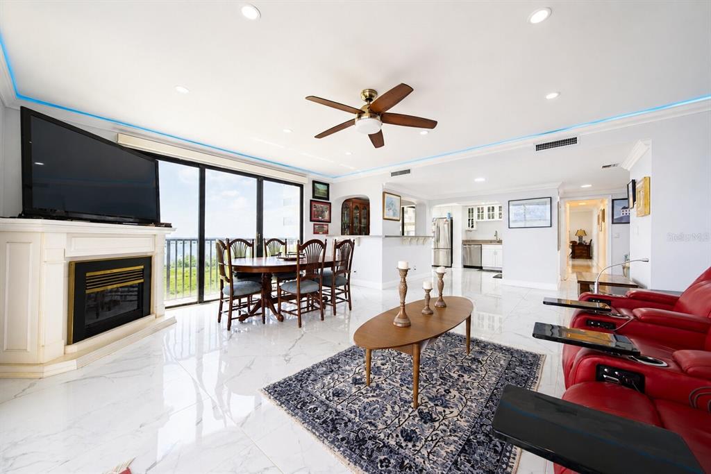 A living and dining area features white marble floors, a fireplace, and red leather recliners — 1501 GULF BOULEVARD UNIT 305, CLEARWATER BEACH, FL