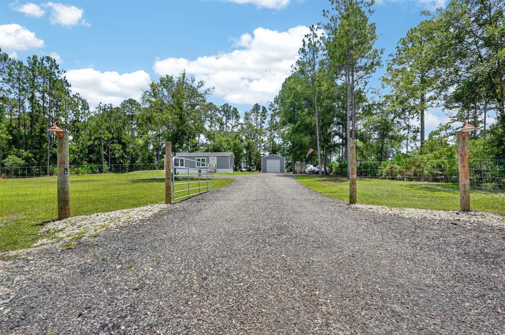 An aerial view shows a house, a detached garage, and a shed on a rural lot — 4825 PECAN AVENUE, BUNNELL, FL