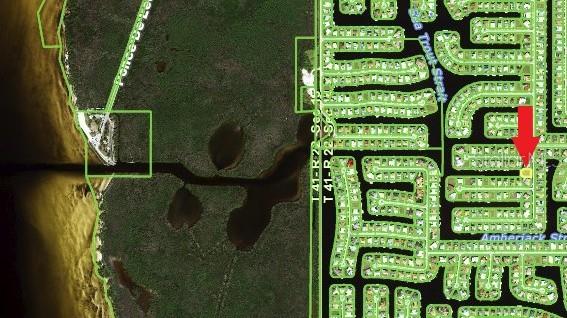 This is a satellite map showing a residential neighborhood with a red arrow pointing to a lot — 1121 CORONADO DRIVE, PUNTA GORDA, FL