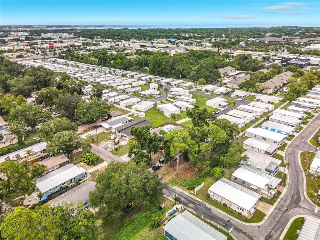 An aerial view shows a residential neighborhood with numerous manufactured homes and mature trees — 381 69TH STREET N, CLEARWATER, FL