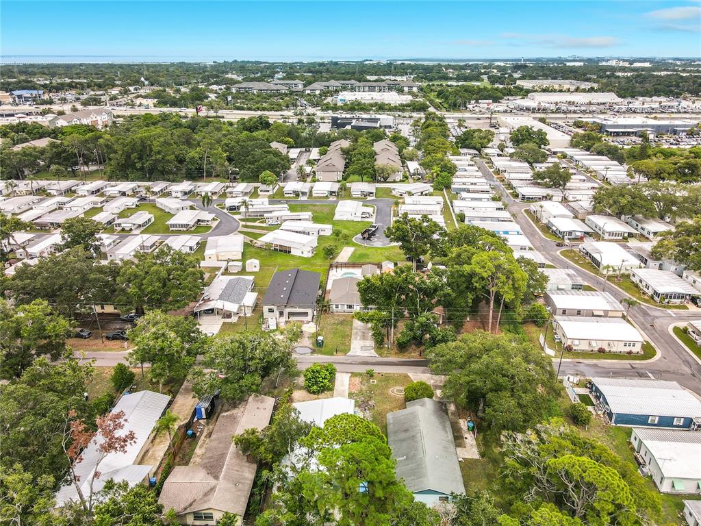 An aerial view shows a residential neighborhood with numerous mobile homes and scattered trees — 381 69TH STREET N, CLEARWATER, FL